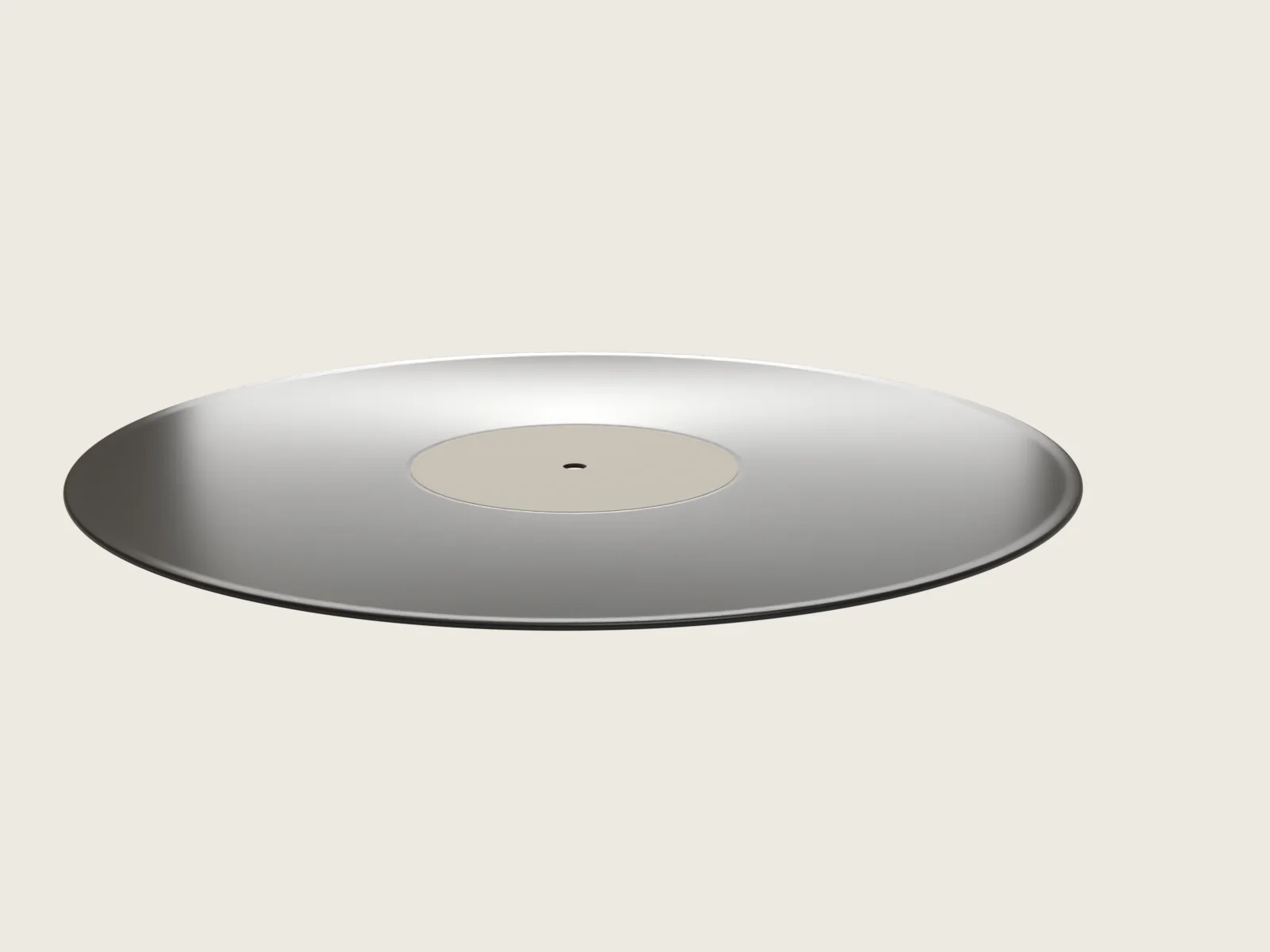 Pressed blank seen from three quarters: rounded teardrop rim and a label seated in its central relief
